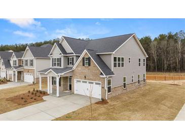 Two-story home with gray siding, brick accents, and a two-car garage at 13958 Conrad Court Ln, Covington, GA 30014