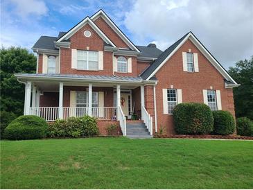 Brick two-story house with a front porch and landscaped lawn at 100 Meadow Lake Dr, Carrollton, GA 30116