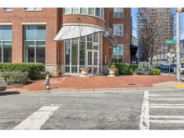 Inviting building entrance with red brick, modern awnings, and well-maintained landscaping at 325 E Paces Ferry Rd # 2003, Atlanta, GA 30305