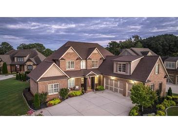 Brick two-story home with a three-car garage and landscaped front yard at 109 Slate Dr, Buford, GA 30518