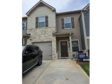 Charming two-story townhome features a brick and siding facade with a convenient attached garage at 2502 Polaris Sw Way, Atlanta, GA 30331