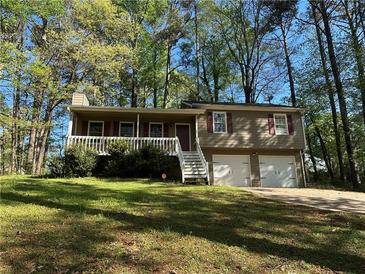 Charming home featuring a front porch, two-car garage, and manicured lawn at 65 Bridge Dr, Douglasville, GA 30134