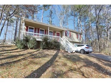 Charming home with a welcoming front porch and well-maintained yard and a white car parked in the drive at 65 Bridge Dr, Douglasville, GA 30134