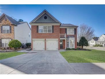 Brick two-story house with a two-car garage and manicured lawn at 194 Friars Head Dr, Suwanee, GA 30024