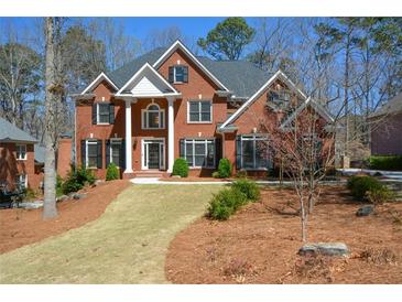 Stately two-story brick home with black shutters and mature landscaping at 1105 River Laurel Dr, Suwanee, GA 30024