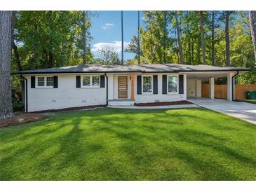 Newly renovated Ranch home with a modern front door and landscaped lawn at 1464 Sanden Ferry Dr, Decatur, GA 30033