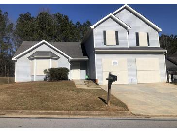 Two-story house with gray siding, a two-car garage, and a neatly landscaped lawn at 5332 Shirewick Dr, Lithonia, GA 30058
