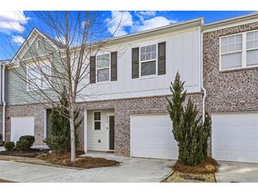 Charming townhome with brick and siding exterior, garage, and well-manicured landscaping at 2056 Wildflower Way, Conyers, GA 30012