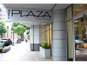 Street view of 'The Plaza Midtown' building entrance with well-maintained landscaping at 44 Peachtree Ne Pl # 926, Atlanta, GA 30309