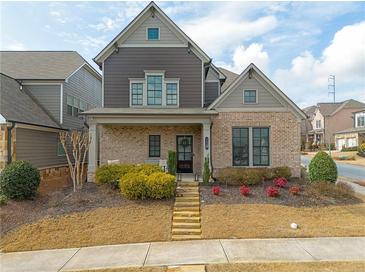 Charming two-story home featuring a well-manicured lawn, brick accents, and a welcoming front porch at 3000 Smyrna Grove Dr, Smyrna, GA 30082