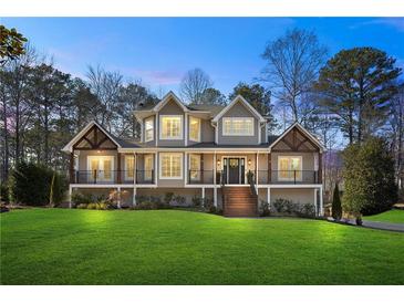 Charming two-story home with a landscaped yard, wooden porch and stairs, and black railings at 3051 Maple Ln, Alpharetta, GA 30009