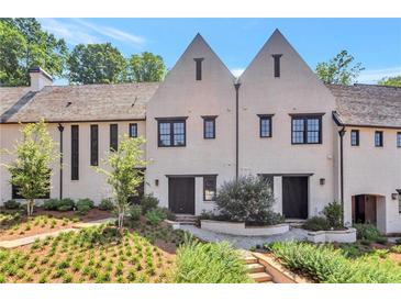 Stunning townhome showcasing manicured front yard, neutral paint, gabled roof, and dark framed windows at 122 Gainey Ln, Chattahoochee Hills, GA 30268