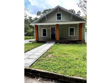 Charming craftsman bungalow with a welcoming front porch and landscaped lawn at 5221 Central Dr, Stone Mountain, GA 30083