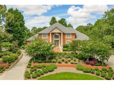 Brick home with landscaped yard and circular driveway at 619 Champions Dr, Mcdonough, GA 30253