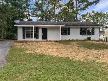 Cozy single-story home featuring black shutters, fresh mulch, and a well-maintained lawn at 9129 Bent Pine Ne Ct, Covington, GA 30014