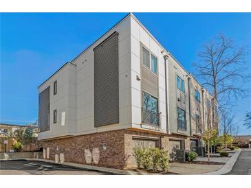 Modern three-story townhome with gray and white exterior, and attached garage at 2199 Lenox Ne Rd # 13, Atlanta, GA 30324