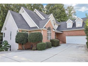 Brick and stucco home with a two-car garage and lush landscaping at 135 Eagles Club Dr, Stockbridge, GA 30281