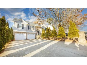 Two-story house with a double garage and manicured landscaping at 571 Oak Vista Ct, Lawrenceville, GA 30044