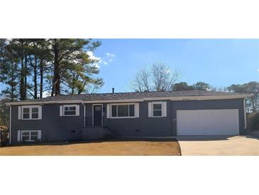 Newly renovated ranch home featuring a gray exterior, white garage door, and landscaped lawn at 1800 Pinedale Nw Dr, Atlanta, GA 30314