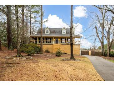 Charming raised ranch home with a spacious deck and landscaped yard at 44 Browns Ct, Powder Springs, GA 30127