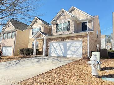 Two-story house with a stone and beige facade, two-car garage, and a neat front yard at 585 Briarhurst Ct, Lawrenceville, GA 30046