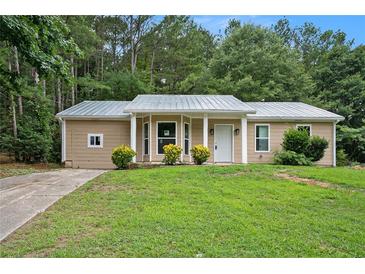 Newly renovated ranch home with a metal roof and landscaped lawn at 6945 Brown S Dr, Fairburn, GA 30213