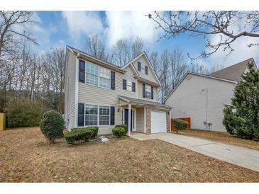 Two-story house with beige vinyl siding, black shutters, and a white garage door at 3542 Brookstone Way, Union City, GA 30291