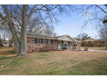 Charming brick home with dark shutters and a well-maintained front yard, perfect for Gathering living at 1155 Casteel Rd, Powder Springs, GA 30127