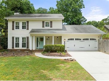 Charming two-story home features a manicured lawn, inviting entrance, and attached two-car garage at 6006 Lanier Heights Cir, Buford, GA 30518