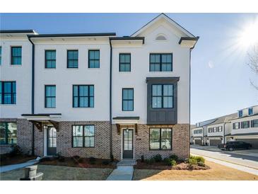 White brick front of charming townhome with dark gray accents at 601 Millcroft Blvd, Buford, GA 30518