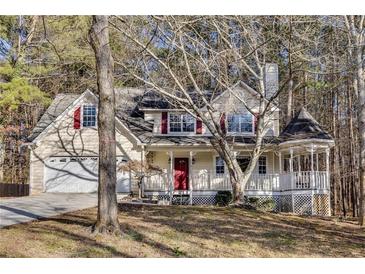 Two-story house with a wraparound porch and attached garage at 4684 Pine Dr, Loganville, GA 30052