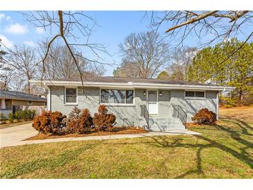 Charming ranch home with gray brick exterior and landscaped yard at 1021 Magnolia Se Dr, Smyrna, GA 30082