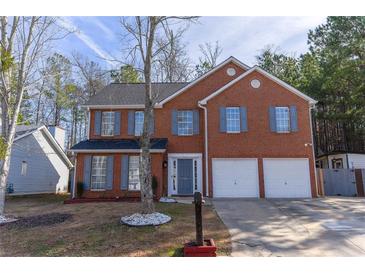 Brick house with two-car garage and landscaping at 3886 Cedar Trace Ln, Ellenwood, GA 30294