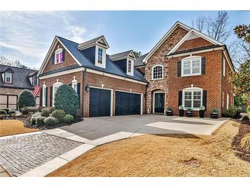 Elegant brick home featuring a three-car garage, manicured landscaping, and a welcoming entrance at 1250 Atherton Park, Roswell, GA 30076