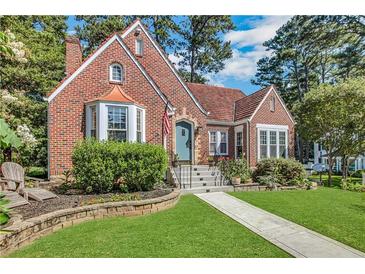 Charming brick home featuring a landscaped front yard, bay window, and inviting entrance at 1290 Pasadena Ne Ave, Atlanta, GA 30306