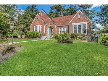 Charming brick home with a well-manicured lawn and beautiful landscaping and a clay tile roof at 1290 Pasadena Ne Ave, Atlanta, GA 30306