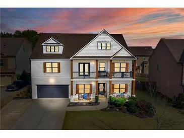Two-story home with white brick, brown accents, and a welcoming front porch at 5060 Lloyd Ln, Cumming, GA 30040
