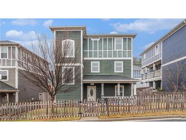 Charming green two-story home featuring a picket fence and well-maintained landscaping at 692 Rose Palm Ln, Atlanta, GA 30315