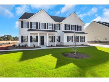 Two story house with white siding, black shutters, and a nicely landscaped lawn at 325 Meuse Ln, Locust Grove, GA 30248