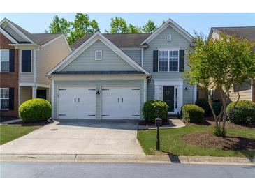 Charming two-story home featuring a two-car garage, lush landscaping, and a welcoming front entrance at 327 Balaban Cir, Woodstock, GA 30188