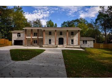 Stately two-story home with a brick facade, prominent columns, and a spacious driveway at 4395 Woodland Brook Se Dr, Atlanta, GA 30339