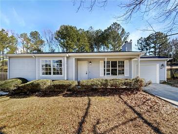 Ranch style home with landscaped lawn and driveway at 2845 Robinson Wood Dr, Riverdale, GA 30296