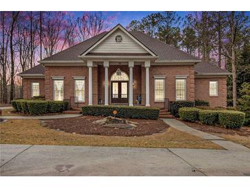 Brick home with a large front porch and landscaped yard at 130 Wesleyan Way, Oxford, GA 30054
