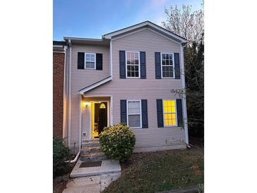 Two-story tan house with navy shutters, stone steps, and well-lit entryway at 1537 Cedar Bluff Trl, Marietta, GA 30062