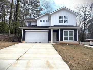 Two-story house with white and dark siding, a white garage door, and a long driveway at 2148 Lilac Ln, Decatur, GA 30032