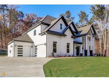 Two-story home with white siding, black accents, and a three-car garage at 1010 Nours Cir, Lawrenceville, GA 30045