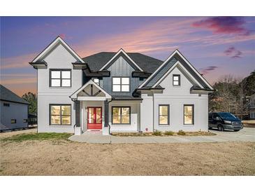 Stunning two-story home showcasing a modern design with black trim windows and a welcoming red front door at 1010 Nours Cir, Lawrenceville, GA 30045