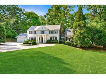 Charming two-story home with a manicured lawn and circular driveway surrounded by lush greenery at 3382 Habersham Rd, Atlanta, GA 30305