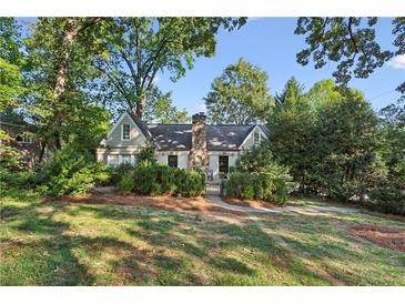 Charming home with lush landscaping, mature trees, and a stone chimney at 250 Lakeview Ne Ave, Atlanta, GA 30305