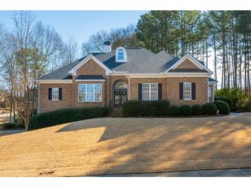 Brick house with a large yard and mature trees at 412 Mallory Cir, Loganville, GA 30052